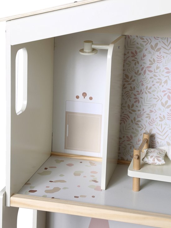 Detail van de bovenste verdieping van het poppenhuis, met een houten bedje en douche-illustratie op de muur.