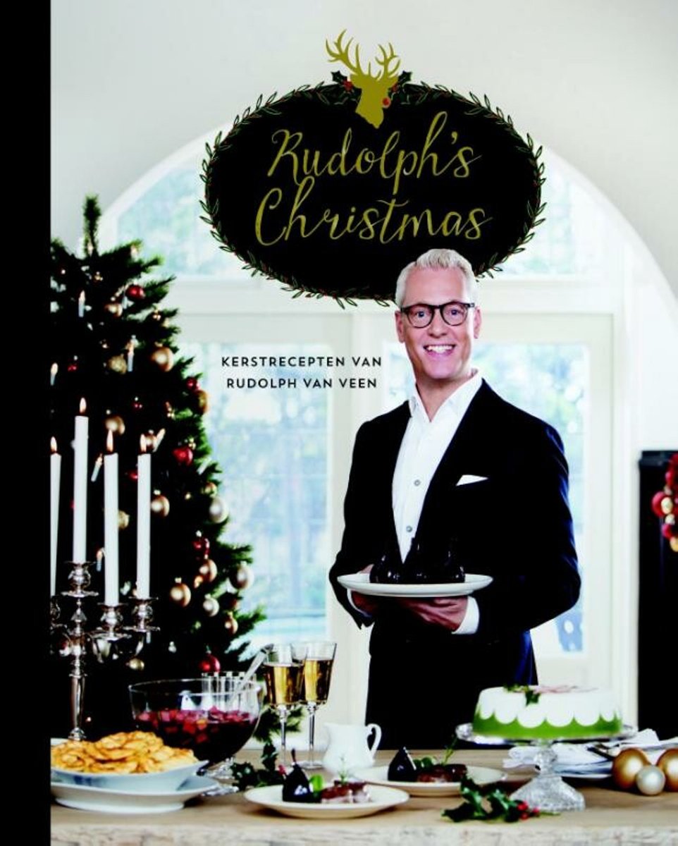 Rudolph van Veen met een kerstdecor en kerstboom, die een chocoladetaart vasthoudt. Op tafel staan kerstversieringen en gebak.
