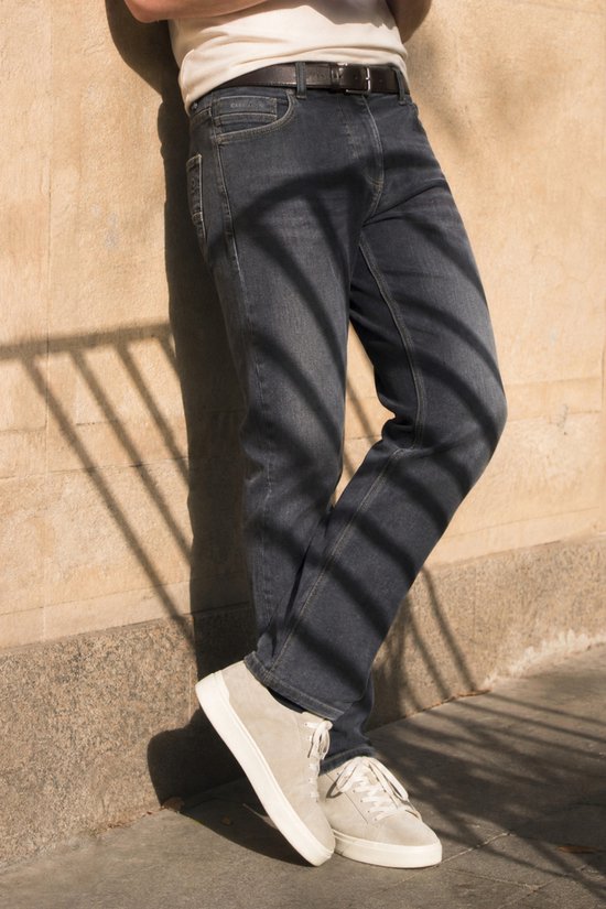 Gabbiano Arctic relaxed jeans in antraciet, model leunend tegen muur met schaduwpatroon, beige sneakers.
