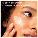 Vrouw brengt serum aan op haar gezicht, met de tekst 'Boost de Nutrition Barrière cutanée renforcée'.