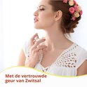 Vrouw sprayt parfum op de nek met bloemenkrans in haar haar.
