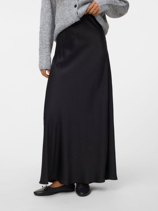 Jupe longue noire en satin à taille haute, portée par un mannequin avec un pull en tricot gris.