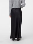 Jupe midi noire en satin taille haute, portée par un mannequin avec un pull gris.