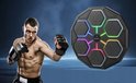 Bokstrainer met 6 led-panelen, een digitaal display. Een spierbundige man met bokshandschoenen slaat naar de trainer.