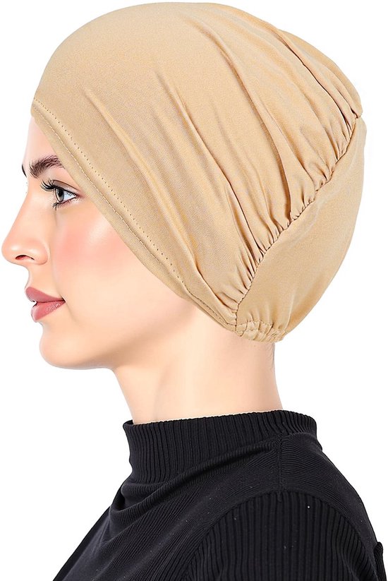Vrouw in profiel met een beige hoofdband die haar haar bedekt, met een zwarte coltrui.