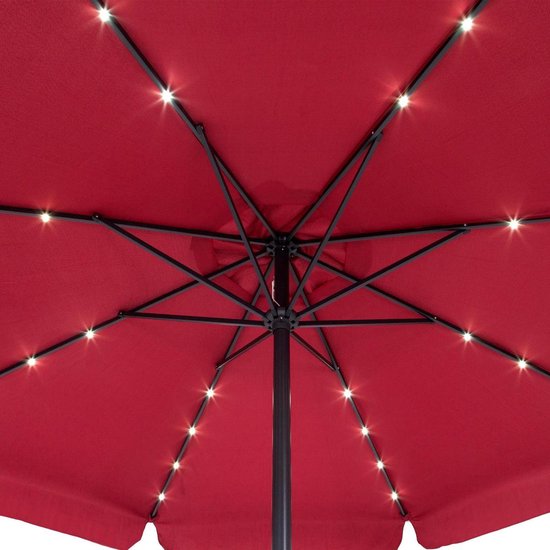 Onderkant van een open rode parasol met zwarte baleinen en led-lampjes.
