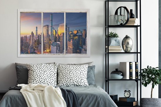 Toile avec vue sur la skyline de New York au coucher du soleil, accrochée au-dessus d'un lit double.