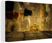 Canvas Schilderij Barman schenkt glas whisky in - 120x80 cm - Wanddecoratie
