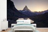 Behang - Fotobehang De Matterhorn en de Riffelsee bij zonsopkomst in Zwitserland - Breedte 420 cm x hoogte 280 cm
