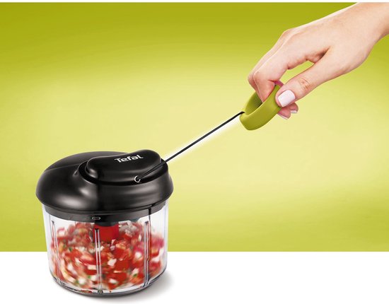 Hand gebruikt de Tefal hakmolen met touwtje om fijngesneden tomaten in een glazen container te maken.