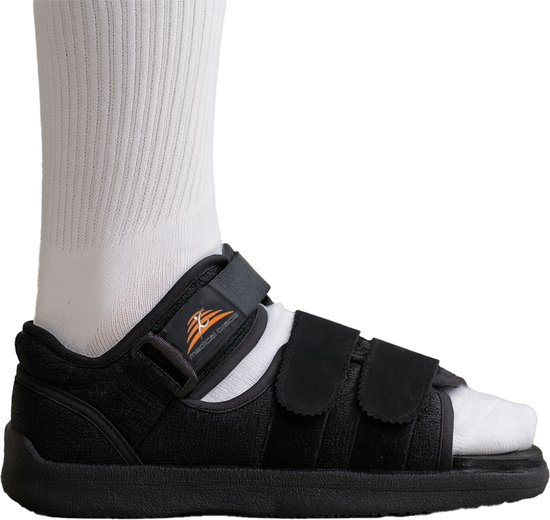 Zwarte gipschoen met klittenbandsluiting en witte sok. Medical Brace logo op de zijkant.