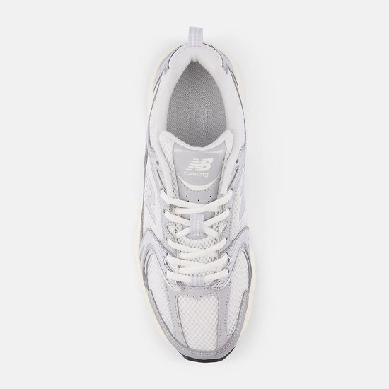 Bovenkant van de zilverkleurige New Balance U530 sneaker, met 'running' logo op de tong.