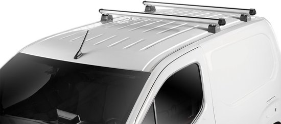 Deux galeries de toit en aluminium avec pieds noirs sur le toit d'une fourgonnette blanche.