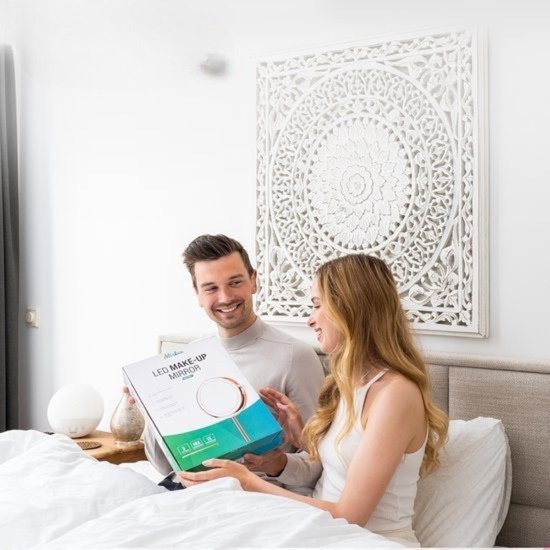 Een man en vrouw met een Mirlux LED make-up spiegel in de slaapkamer.