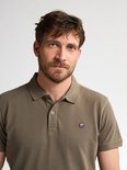Portret van een man met baard in een olijfgroen poloshirt met het Petrol Industries logo op de borst.