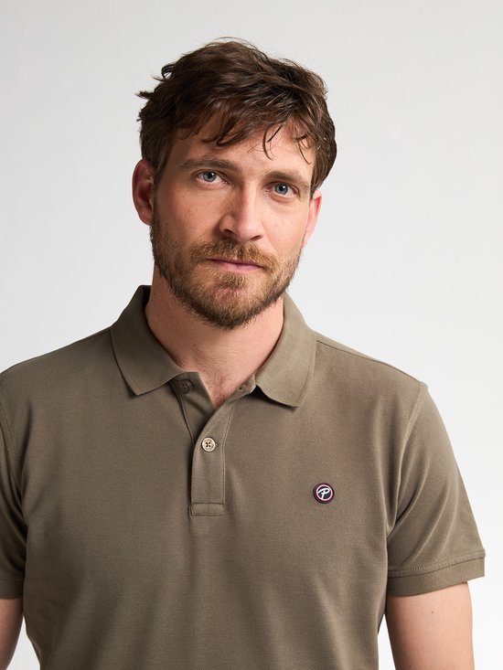 Portret van een man met baard in een olijfgroen poloshirt met het Petrol Industries logo op de borst.