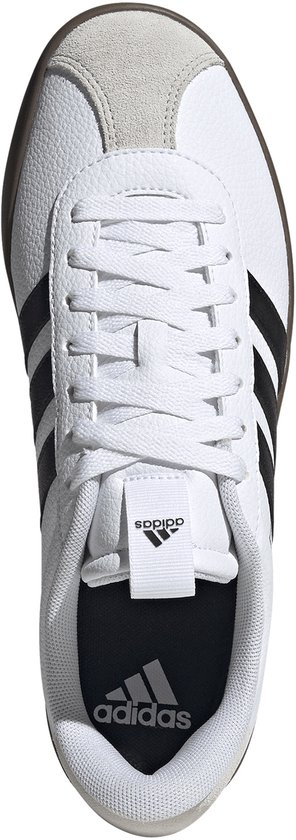 Witte adidas sneaker met zwarte strepen, grijze neus en bruine zool. Van bovenaf gezien.