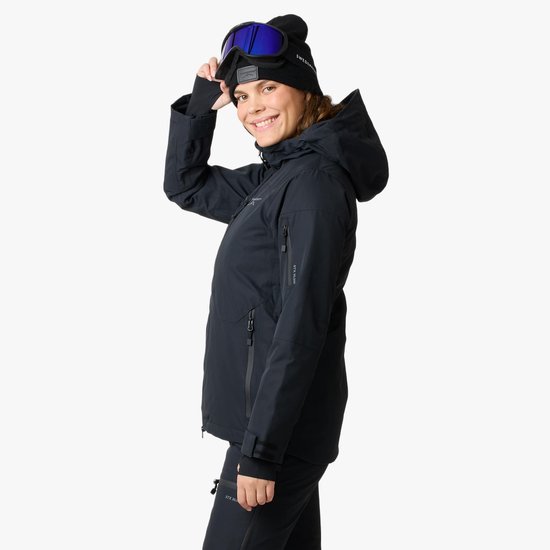 Dames ski-jas, zwart, met capuchon, skibril en muts, profiel.