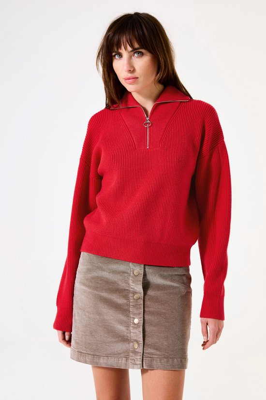 Mannequin portant un pull en maille rouge à demi-zip et une jupe en velours côtelé marron.