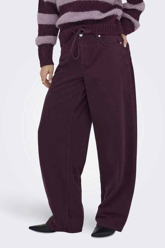 Model met paarse wijde broek met trekkoord en strik. Draagt een gestreepte trui.