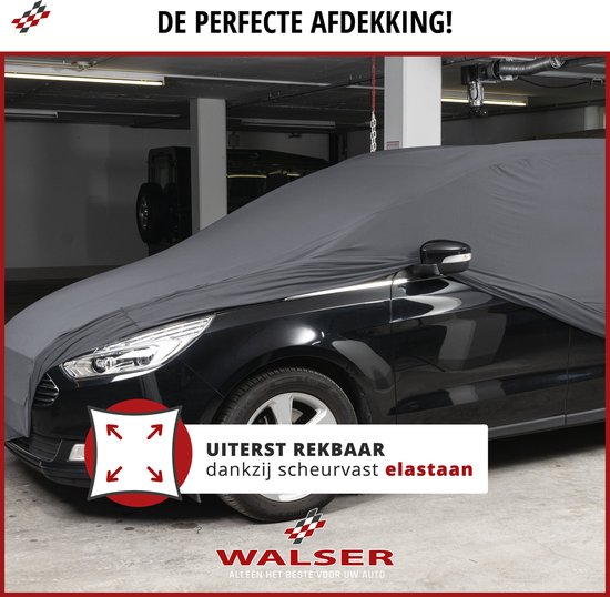 Zwarte auto met grijze, uiterst rekbare autohoes van elastisch materiaal, in een garage.