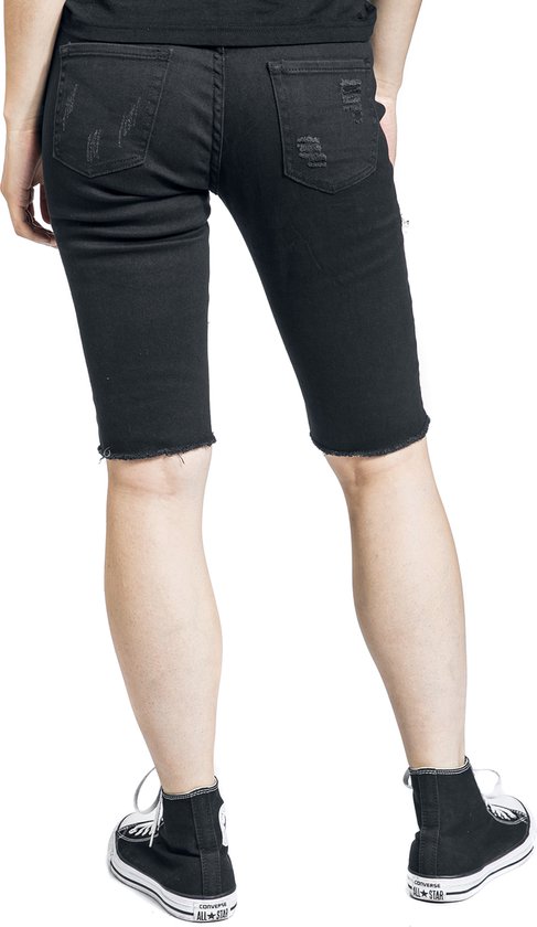 Zwarte shorts met rafelige zoom en lichte distressed details, gedragen met zwarte sneakers.