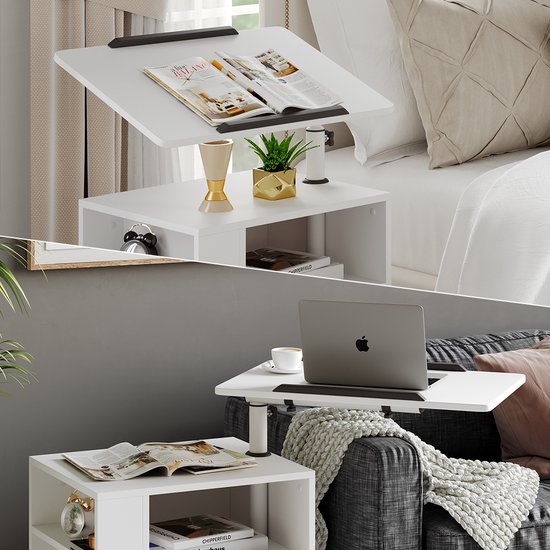 Table de chevet blanche avec des magazines sur le plateau réglable, et un ordinateur portable sur un autre plateau. Utilisée près d'un lit et d'un canapé.