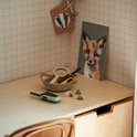 Groene en oranje Kidywolf KIDYTALK walkietalkies op een houten bureau, met tekeningen aan de muur.