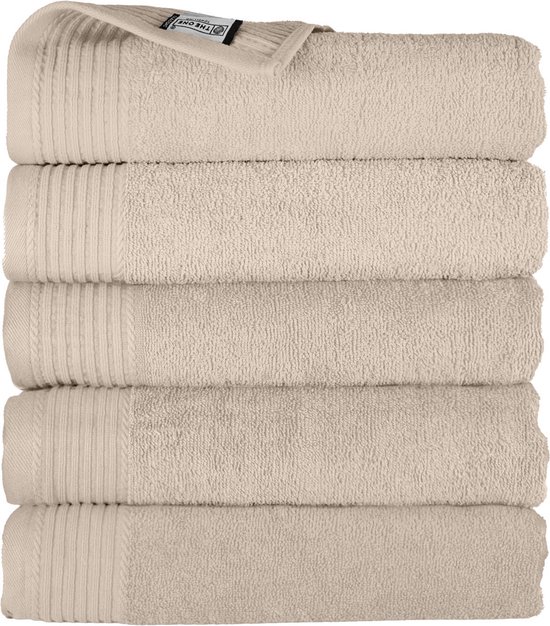 Stapel van vijf beige katoenen handdoeken, met ribbed detail en label.