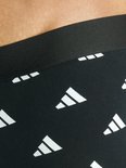 Close-up van zwarte boxer met herhalend wit Adidas logo op de band.