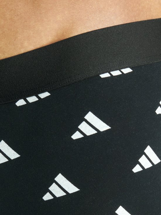 Close-up van zwarte boxer met herhalend wit Adidas logo op de band.
