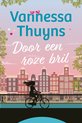 Boekomslag met de titel 'Door een roze bril' door Vannessa Thuyns. Een silhouet van een vrouw op de fiets voor een rij panden.