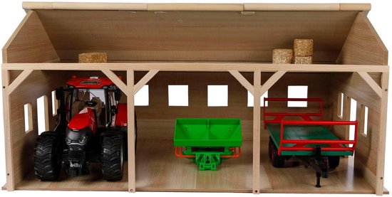 Houten landbouwloods met rode tractor, groene aanhanger en hooi. Drie open ruimtes.
