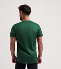 Man met donkergroen, kortemouw hardloopshirt van Rogelli, van achteren gezien.