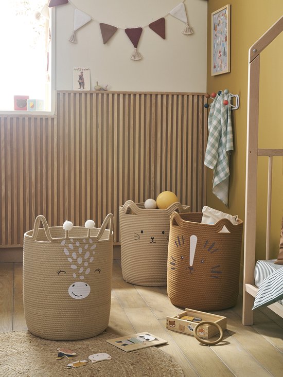 Trois paniers de rangement dans une chambre d'enfant: un panier beige avec visage de girafe, un panier beige avec visage de chat et un panier marron avec visage de tigre.