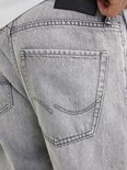 Detail van de achterzakken van een lichtgrijze jeans.