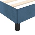 Détail du coin d'un cadre de lit en velours bleu foncé avec un pied noir.