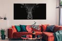 Toile noir et blanc d'un taureau sur fond sombre, au-dessus d'un canapé d'angle orange.