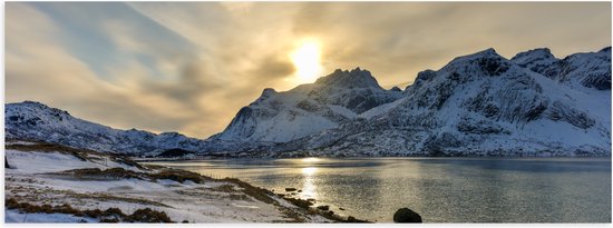 Liggende poster van een besneeuwd berglandschap en water bij een gouden zonsondergang.