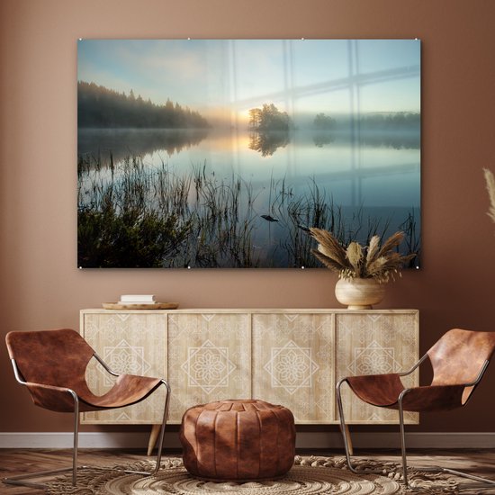 Une peinture sur verre d'un lever de soleil sur un lac brumeux, dans un salon avec des chaises marron.