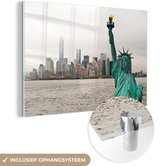 MuchoWow® Glasschilderij 90x60 cm - Schilderij acrylglas - De horizon van Manhattan en het Vrijheidsbeeld bij New York in Amerika - Foto op glas - Schilderijen