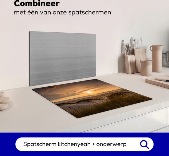 Inductiebeschermer met duinenlandschap bij zonsondergang, naast een metalen spatbord.