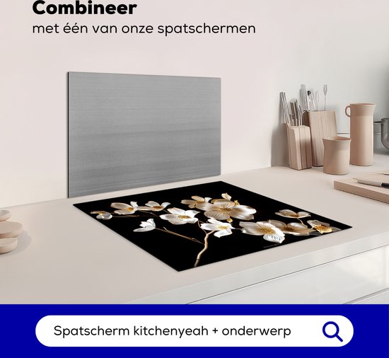 Glazen snijplank met witte en gouden bloemen, naast een spatbord.