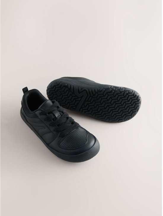Zwarte leren veter-sneakers, met perforaties op de neus en de onderkant van de zool met profiel.