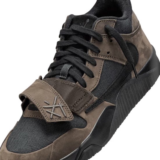Close-up van een bruine en zwarte lage sneaker met klittenbandsluiting en veters.