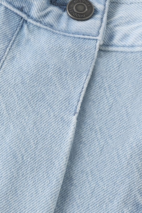 Detailopname van de knoopsluiting van een lichtblauwe denim skort. Knoop met het Noppies logo.