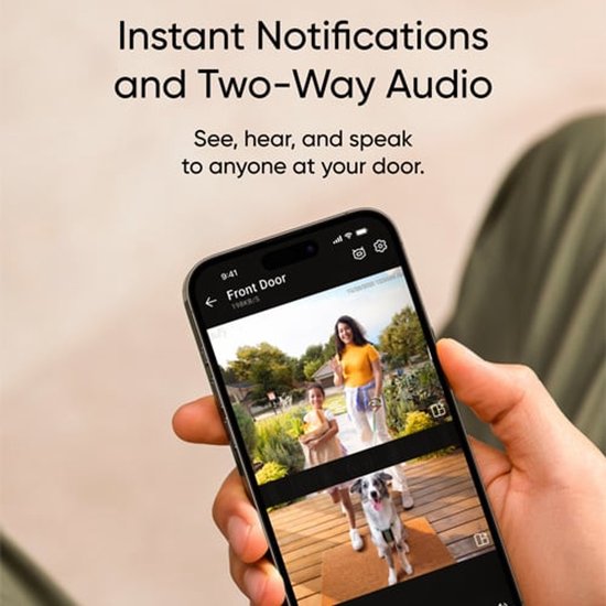 Une main tient un smartphone affichant un flux vidéo en direct d'une femme, d'un enfant et d'un chien.
