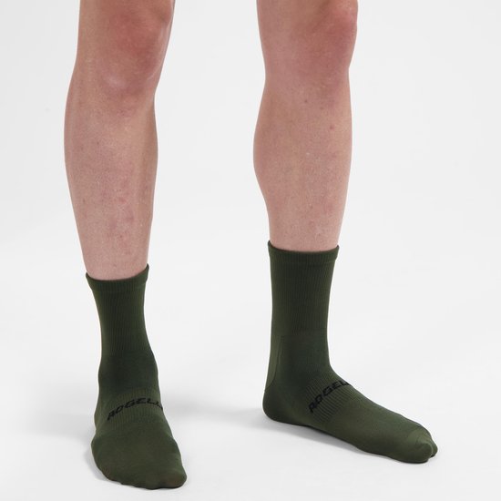 Donkergroene fietssokken, tot halverwege de kuit, met zwart Rogelli logo op de zool.