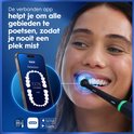 Vrouw poetst tanden met zwarte Oral-B iO tandenborstel. De Oral-B app toont 100% dekking.
