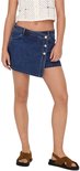 Model draagt een korte, donkerblauwe denim rok met een overslagsluiting, knopen en een asymmetrische zoom.